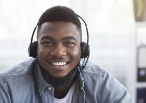 Portrait of friendly black customer support manager in headset